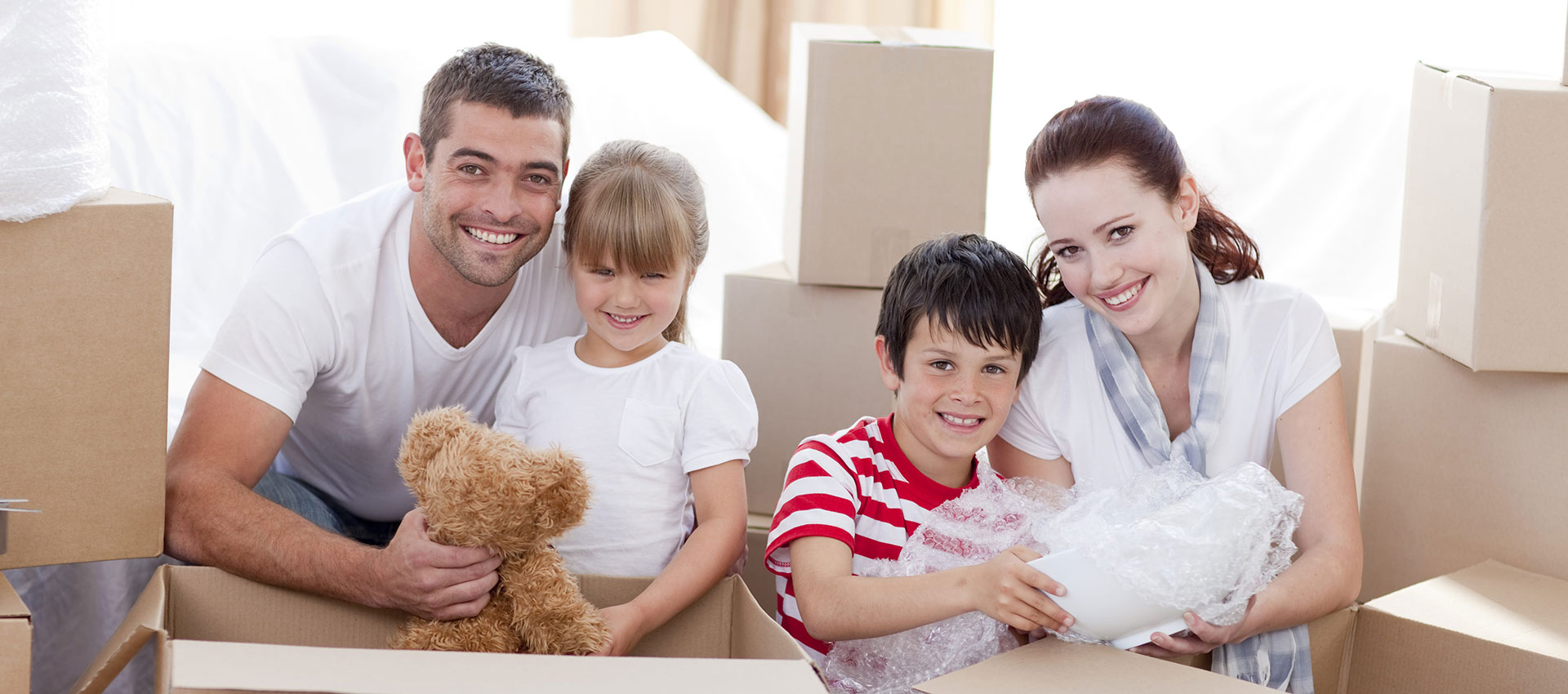 A family happily unpack items moved by the Box Truck Couriers company.